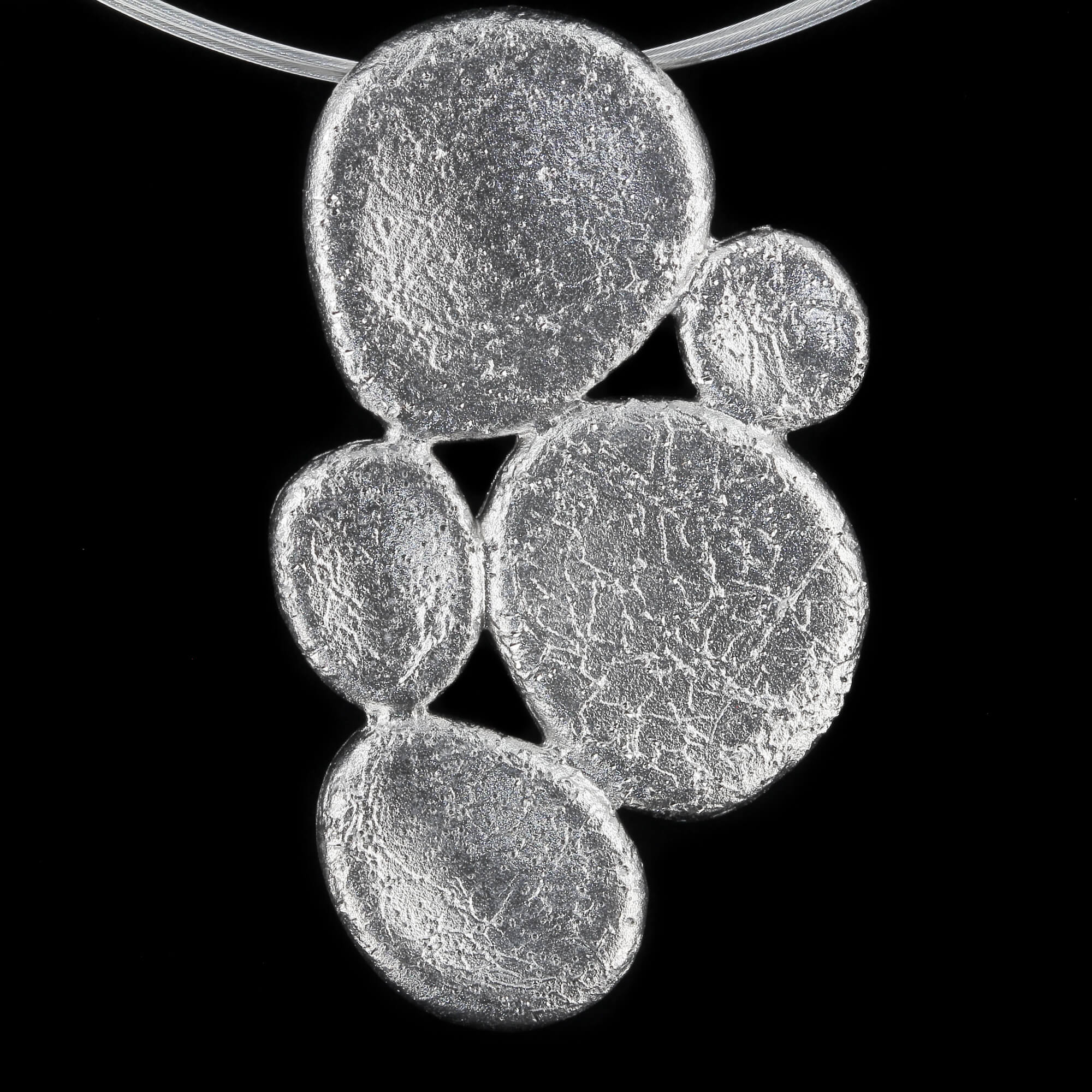 Beautiful silver pendant of 3 small and 2 larger closed and edited ovals. Very chic on the ear. Sanjoya Design