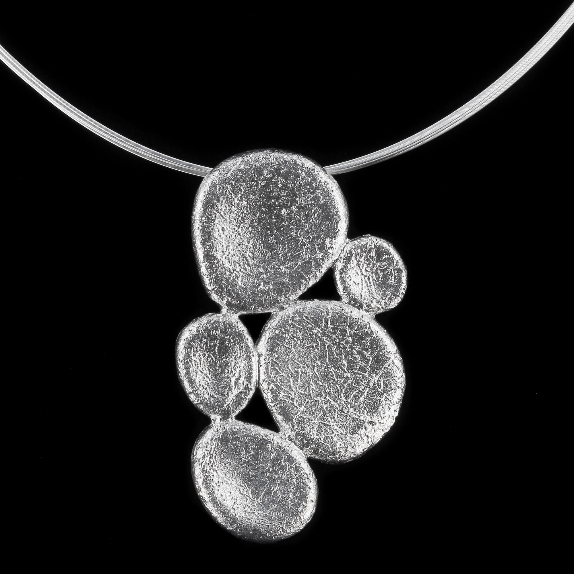 Beautiful silver pendant of 3 small and 2 larger closed and edited ovals. Very chic on the ear. Sanjoya Design