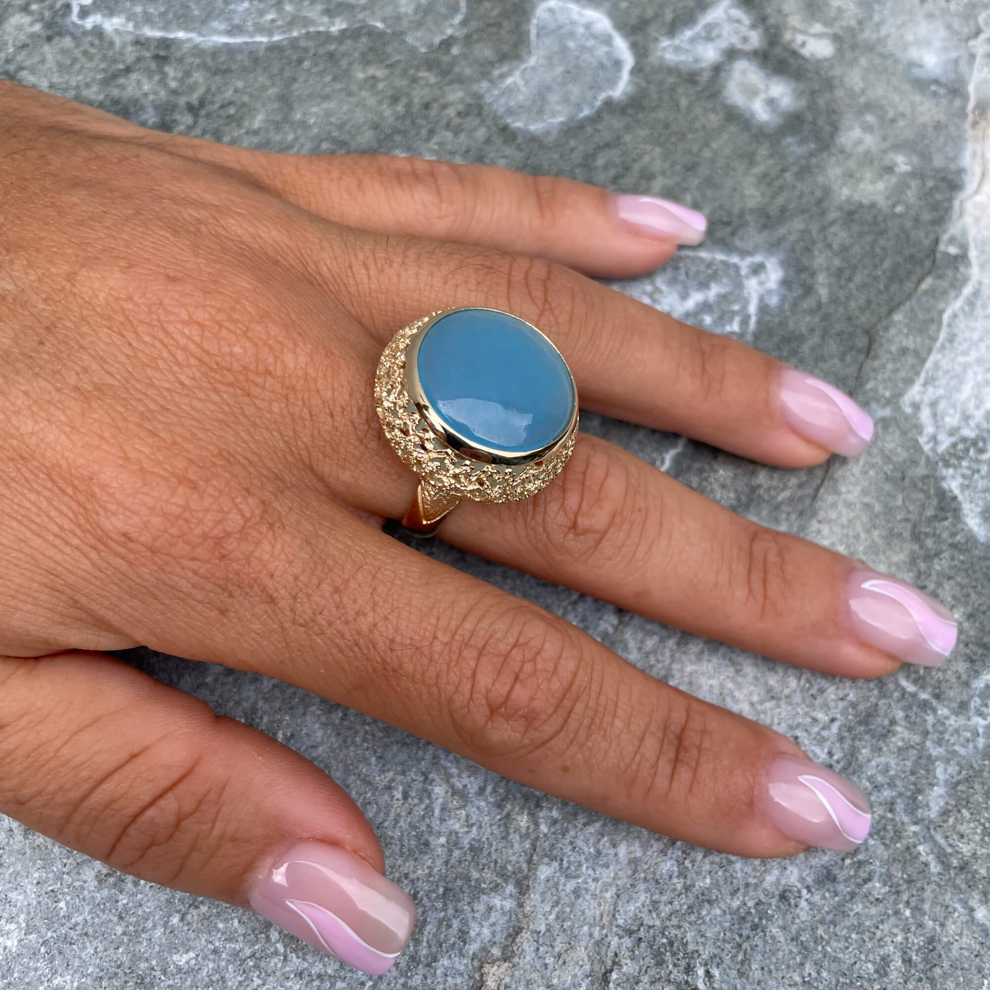 Bewerkte vergulde ring met een blauwe quartz steen