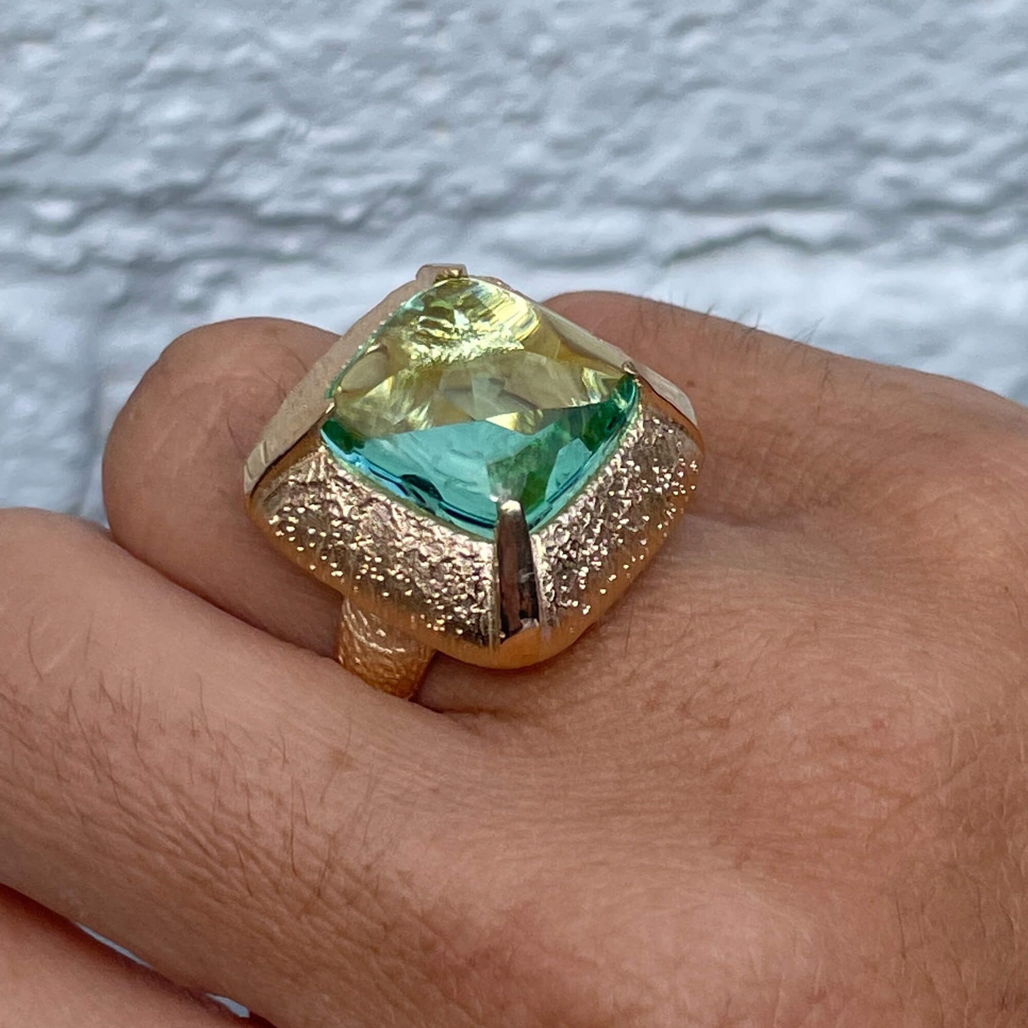 Vergulde vierkantvormige ring met een groene steen